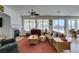 Open-concept living area featuring brick fireplace, plush furnishings, and pool views at 10290 Marion Morrison Ct, Las Vegas, NV 89183