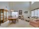 Bright and spacious living room with high ceilings, large windows, floral patterned furniture and formal dining area at 10290 Marion Morrison Ct, Las Vegas, NV 89183