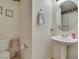 Cozy powder room featuring pedestal sink, floral accents, and tile flooring at 10290 Marion Morrison Ct, Las Vegas, NV 89183