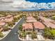 A beautiful aerial view of a neighborhood featuring well-maintained homes with lush greenery and community streets at 10294 Running Falls St, Las Vegas, NV 89178