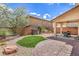 Charming backyard featuring a covered patio, synthetic grass, brick pavers and low maintenance landscaping at 10294 Running Falls St, Las Vegas, NV 89178