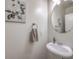 Well-lit half bathroom featuring a pedestal sink, round mirror, and neutral paint at 10294 Running Falls St, Las Vegas, NV 89178
