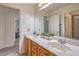 Bathroom featuring a large mirror, double sinks, a shower and ample lighting at 10294 Running Falls St, Las Vegas, NV 89178