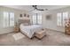 Bright bedroom with plush carpet, a tufted headboard, shuttered windows, and a ceiling fan at 10294 Running Falls St, Las Vegas, NV 89178