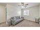 Bedroom featuring a gray sofa, neutral carpet, and a window with plantation shutters at 10294 Running Falls St, Las Vegas, NV 89178