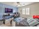 Bedroom with blue accent wall featuring a window with plantation shutters and a ceiling fan at 10294 Running Falls St, Las Vegas, NV 89178