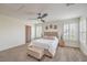 Bright bedroom with plush carpet, a tufted headboard, shuttered windows, and a ceiling fan at 10294 Running Falls St, Las Vegas, NV 89178