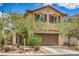 Two-story home featuring a well-maintained lawn, landscaping, and a two car garage at 10294 Running Falls St, Las Vegas, NV 89178