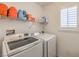 Well-lit laundry room with modern washer and dryer and storage shelves at 10294 Running Falls St, Las Vegas, NV 89178