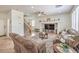 Open concept living room with couches, ceiling fan, media center, and staircase at 10294 Running Falls St, Las Vegas, NV 89178