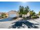 Single story home with a two-car garage and low maintenance desert landscaping in front at 10389 Felice Ave, Las Vegas, NV 89135