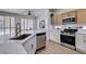 Well-lit kitchen featuring stainless steel appliances, white cabinets, tile backsplash, and a large island at 10389 Felice Ave, Las Vegas, NV 89135