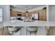 Modern kitchen featuring stainless steel appliances, a large island with seating, and ample natural wood cabinetry at 10389 Felice Ave, Las Vegas, NV 89135