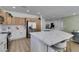 Modern kitchen featuring stainless steel appliances, a large island with seating, and ample natural wood cabinetry at 10389 Felice Ave, Las Vegas, NV 89135
