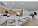 Modern kitchen features stainless steel appliances, a large island with seating, and ample natural wood cabinetry at 10389 Felice Ave, Las Vegas, NV 89135