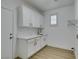 Clean laundry room with white cabinetry, marble countertop, gold hardware, and modern fixtures at 10389 Felice Ave, Las Vegas, NV 89135
