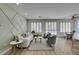 Bright living room area featuring hardwood floors, three large windows, and modern decor at 10389 Felice Ave, Las Vegas, NV 89135