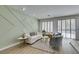 Bright living room area featuring hardwood floors, three large windows, and modern decor at 10389 Felice Ave, Las Vegas, NV 89135