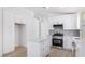 The open kitchen boasts white cabinets, marble counters, stainless appliances, and an island at 10482 Clarion River Dr, Las Vegas, NV 89135