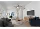 Virtually staged living room with light wood floors, blue accents, a gray sofa, and modern décor for a cozy atmosphere at 10482 Clarion River Dr, Las Vegas, NV 89135