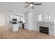 Open-concept living room with wood floors, a fireplace, and a modern kitchen, creating a stylish and functional space at 10482 Clarion River Dr, Las Vegas, NV 89135