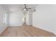 Bright living room features wood floors, a ceiling fan, and white walls providing a clean and modern aesthetic at 10482 Clarion River Dr, Las Vegas, NV 89135