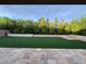 Expansive backyard featuring artificial grass, trees, and a paved patio area, perfect for entertaining at 11318 San Arezzo Pl, Las Vegas, NV 89141