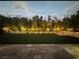 A beautifully landscaped backyard has green turf, trees and recessed lighting at 11318 San Arezzo Pl, Las Vegas, NV 89141
