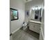 Powder room featuring a modern vanity, framed artwork and wood-look tile flooring at 11318 San Arezzo Pl, Las Vegas, NV 89141