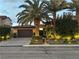 Beautiful front exterior with lush landscaping, a paver driveway, and outdoor lighting at 11318 San Arezzo Pl, Las Vegas, NV 89141