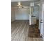 Spacious living room with wood-look floors leading to a compact kitchen area at 1150 N Buffalo Dr # 2093, Las Vegas, NV 89128