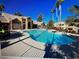Resort-style pool and lounge area surrounded by lush landscaping and palm trees on a sunny day at 1150 N Buffalo Dr # 2093, Las Vegas, NV 89128