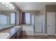 This bathroom features dual sinks with granite counters, warm cabinets, a separate shower, and a bathtub at 11698 Firesteed Pl, Las Vegas, NV 89141