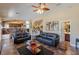 Bright and open living room with tile floors, comfortable sofas, a fireplace, and a view into the kitchen at 11698 Firesteed Pl, Las Vegas, NV 89141
