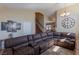 Spacious living room with large sectional sofa, high ceilings, wood staircase, and plenty of natural light at 11698 Firesteed Pl, Las Vegas, NV 89141