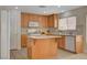 Well-lit kitchen with tile floors, wood cabinets, and a central island at 11919 Jersey Lilly St, Las Vegas, NV 89183
