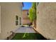 Narrow backyard patio with concrete pad and artificial grass, offering a private outdoor space at 11919 Jersey Lilly St, Las Vegas, NV 89183