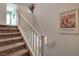 Carpeted staircase with white railing ascends to the upper level, adorned with decorative wall art at 11919 Jersey Lilly St, Las Vegas, NV 89183