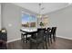 Elegant dining room with a dark wood table, seating for six, and natural light from large windows at 12341 Ferry Glide Ave, Las Vegas, NV 89138