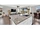Open kitchen featuring a large island with a stone countertop and stainless steel sink overlooking the spacious living area at 12341 Ferry Glide Ave, Las Vegas, NV 89138