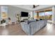 Spacious living room with a gray sectional, large windows, and access to the outdoor pool area at 12341 Ferry Glide Ave, Las Vegas, NV 89138