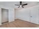 A bedroom with light wood floors, ceiling fan, closet, and white painted door at 1401 E Clark Ave, Las Vegas, NV 89101