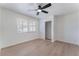 Bright bedroom with light wood floors, ceiling fan, closet, and a window with blinds at 1401 E Clark Ave, Las Vegas, NV 89101