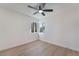 A bedroom with light wood floors, a ceiling fan, and bright light from the double window at 1401 E Clark Ave, Las Vegas, NV 89101
