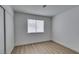 Bright, minimalist bedroom with wood-look floors, white walls, and a window with blinds at 1744 La Cruz Dr, Henderson, NV 89014