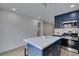 Kitchen features blue cabinets, stainless steel appliances, marble countertops and an island with seating at 1744 La Cruz Dr, Henderson, NV 89014