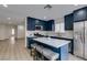 Modern kitchen with blue cabinets, stainless steel appliances, and a marble countertop island with seating at 1744 La Cruz Dr, Henderson, NV 89014