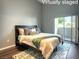 Staged bedroom with dark wood floors, area rug, and sliding doors to balcony at 1881 W Alexander Rd # 1035, North Las Vegas, NV 89032