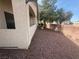 Low-maintenance side yard with desert rock landscaping and mature trees provides a private outdoor space at 1881 W Alexander Rd # 1035, North Las Vegas, NV 89032