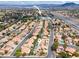Aerial view of a neighborhood showcasing homes with pools, tile roofs, and mountain views at 2024 Spruce Brook Dr, Henderson, NV 89074